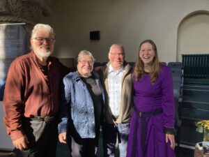 George & Joan Owens stand between Roddy and Connie MacLeod at the GLO Center in Milngavie William Ridley and the Celtic Cross book event November 2024. They are all smiling as sunshine seeps in through windows above. George Owens is the founder and director of Scotland for Jesus.