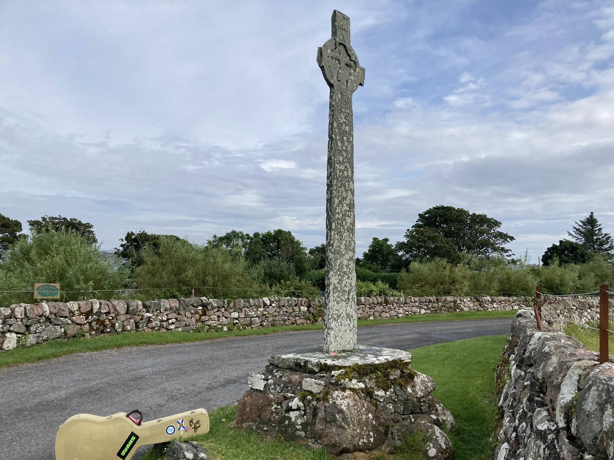 Connie MacLeod's guitar case sitting beside a Celtic Cross on the Isle of Iona
